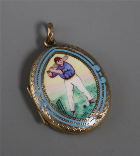 A late Victorian engraved yellow metal and enamel oval locket, decorated with a cricketer, 32mm.